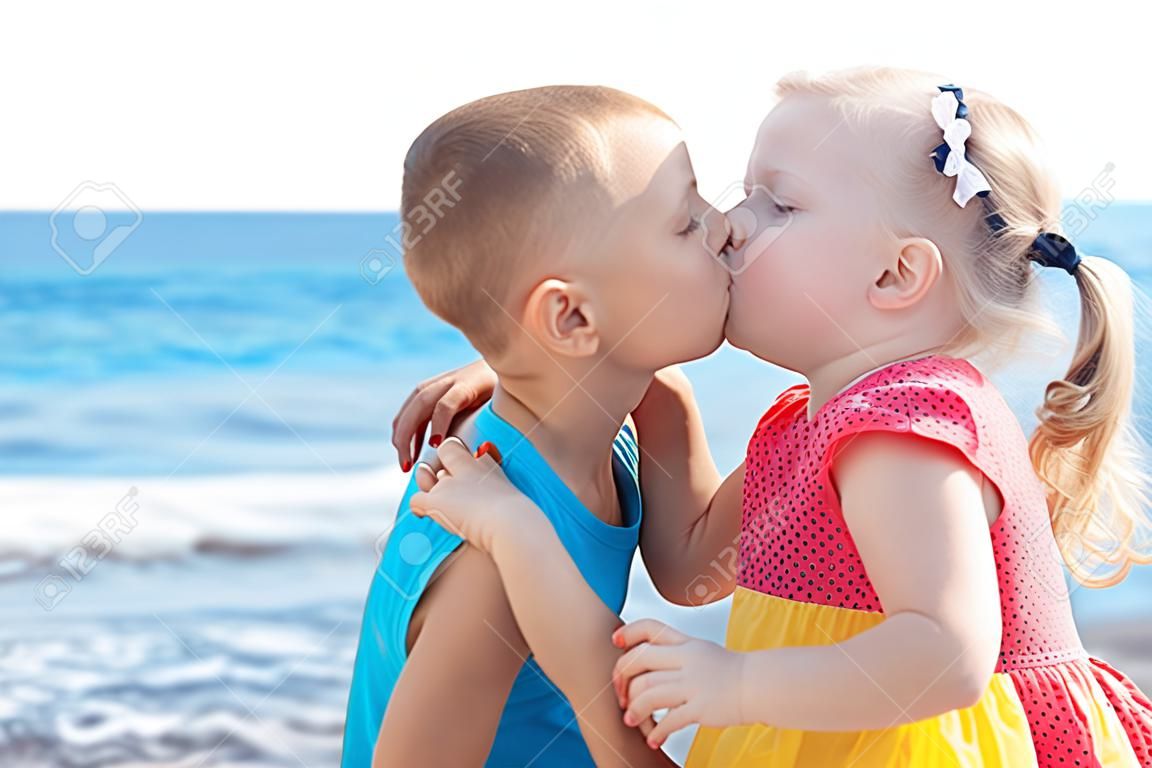 Retrato de dos niños que se besan en la playa