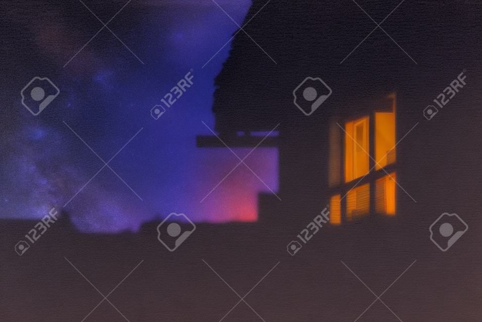 The sky after sunset reflected in the window of a village house