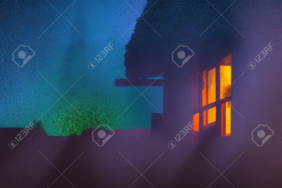 The sky after sunset reflected in the window of a village house