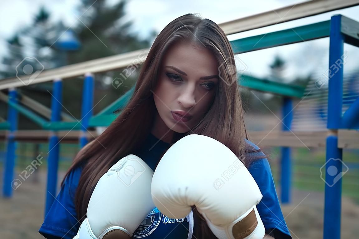 Boxer girl outdoors. The concept of a strong girl,