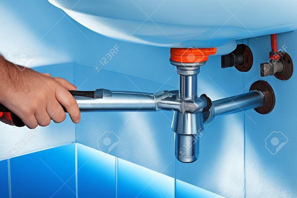 plumber fix sink drain with pipe-wrench