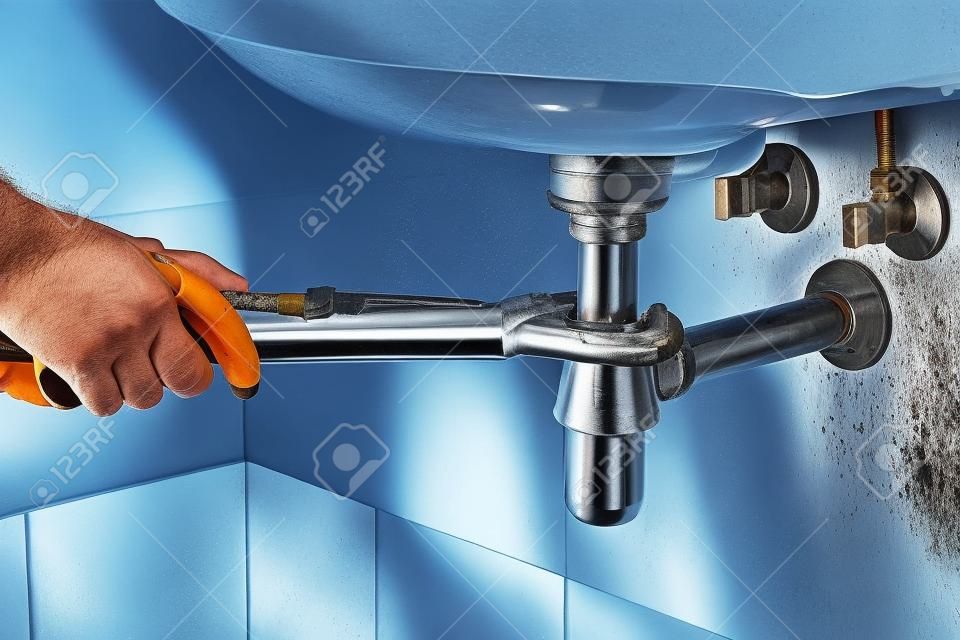 plumber fix sink drain with pipe-wrench