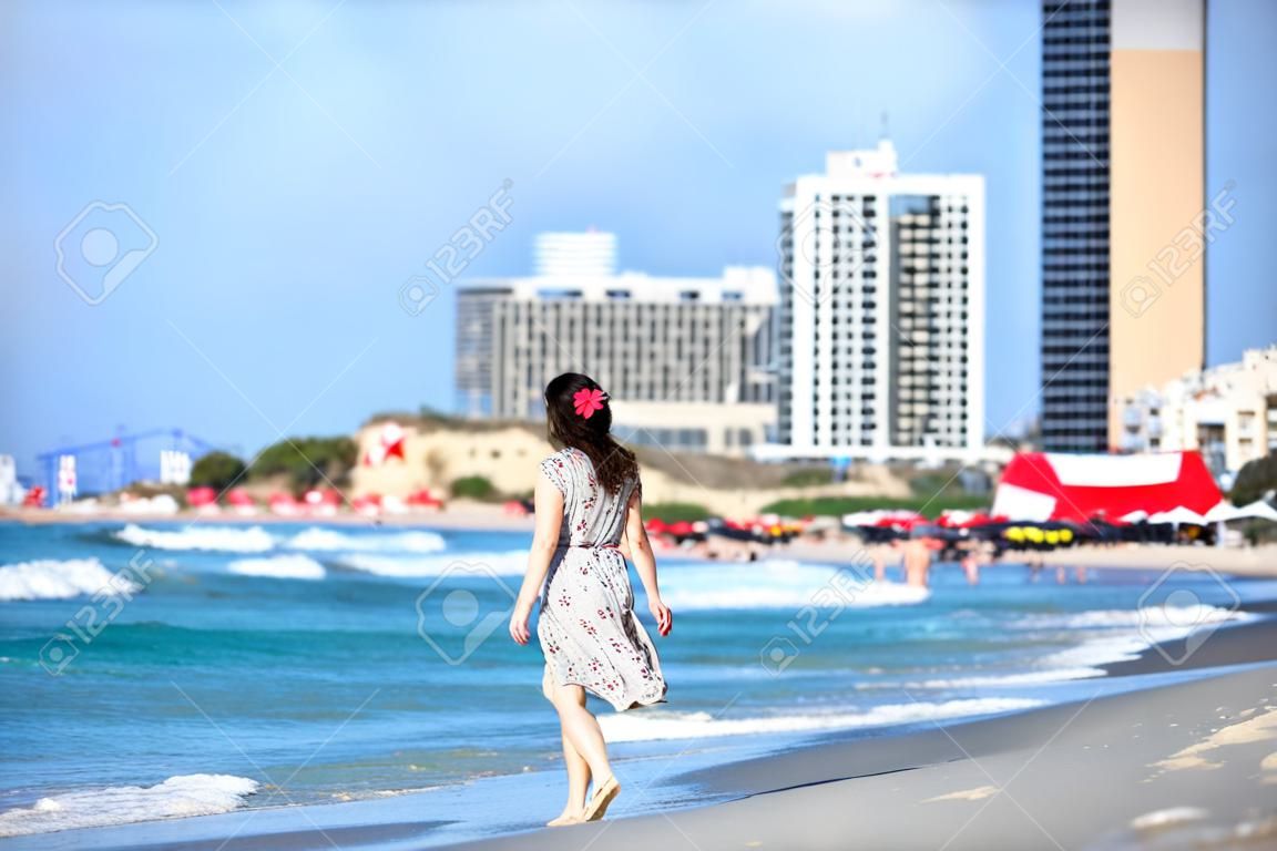 Giovane donna che cammina sulla spiaggia di Tel-Aviv