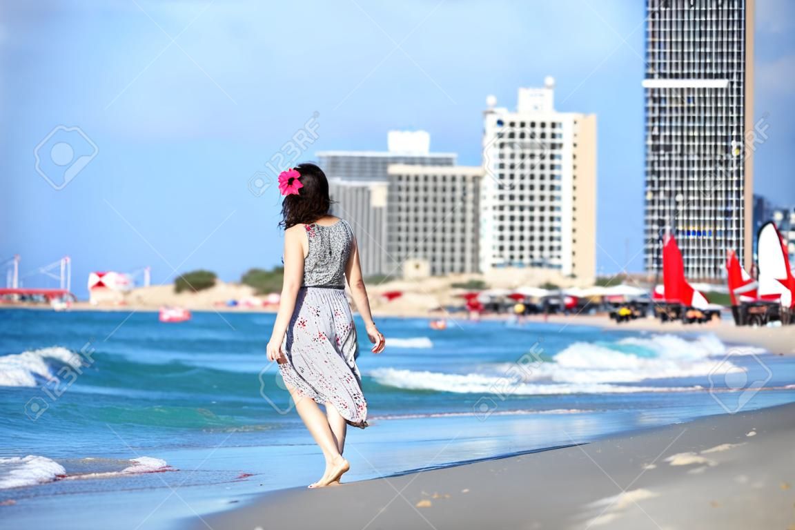Giovane donna che cammina sulla spiaggia di Tel-Aviv
