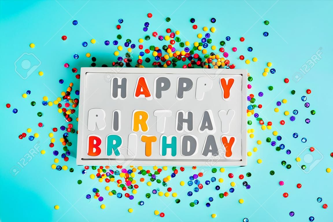 Lightbox con testo buon compleanno e confettini di zucchero colorati vista dall'alto