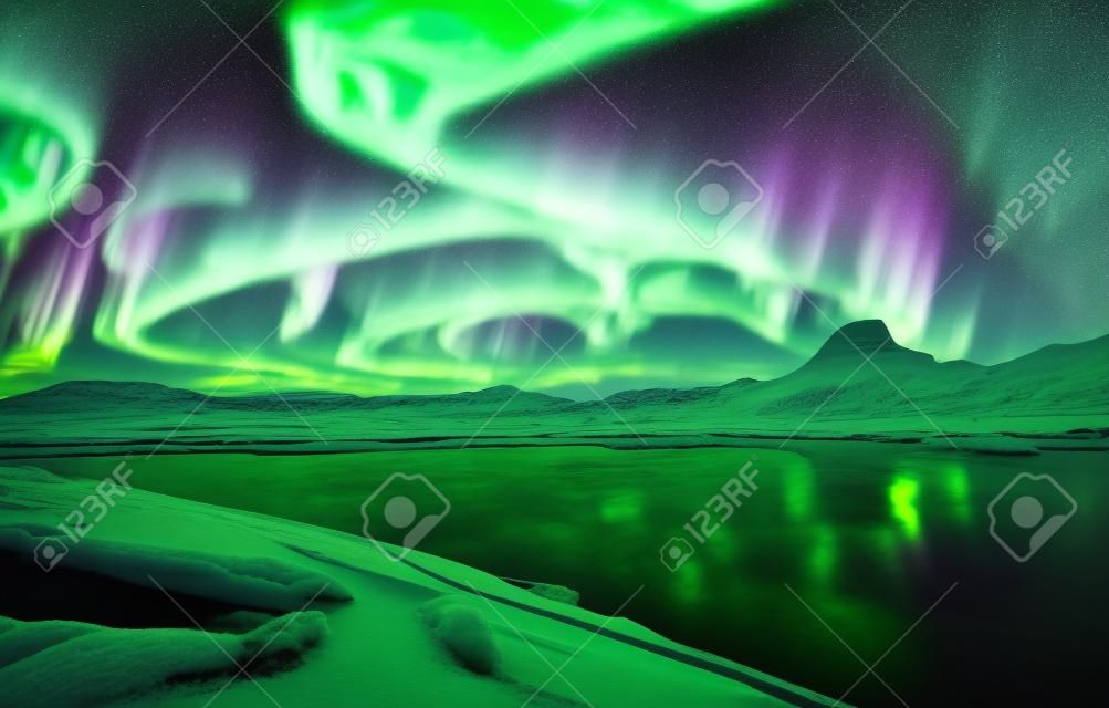 Aurora boreal na noruega. luzes verdes do norte acima das montanhas. céu noturno com luzes polares. paisagem noturna do inverno com aurora e reflexão na superfície da água. costas naturais