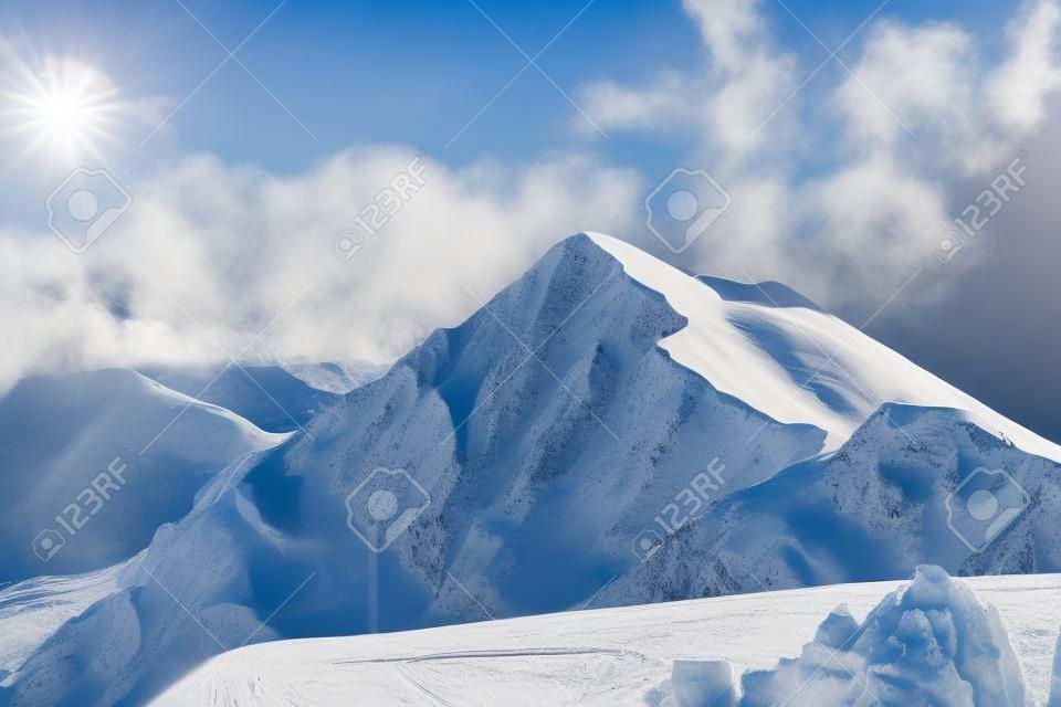 Mountain landscape, ski resort Krasnaya Polyana. Russia, Sochi, Caucasus Mountains. Snowboard tracks on snowy mountain slope.