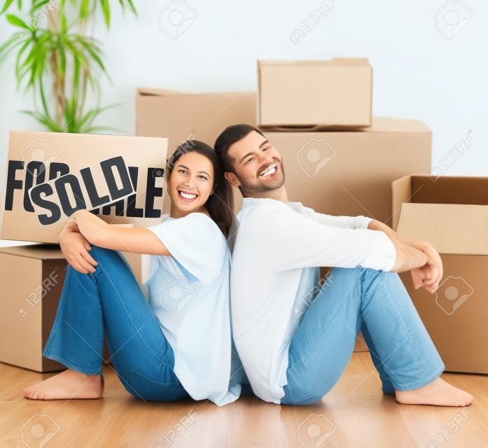 Happy couple with unpacking boxes moving to a new house