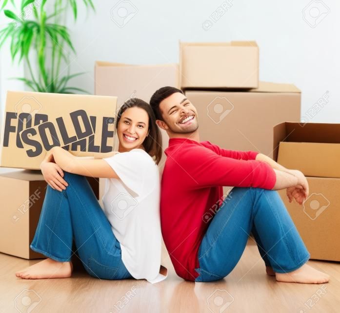 Happy couple with unpacking boxes moving to a new house