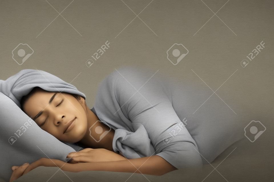 Una mujer que duerme con los brazos extendidos un poco fuera delante de ella.