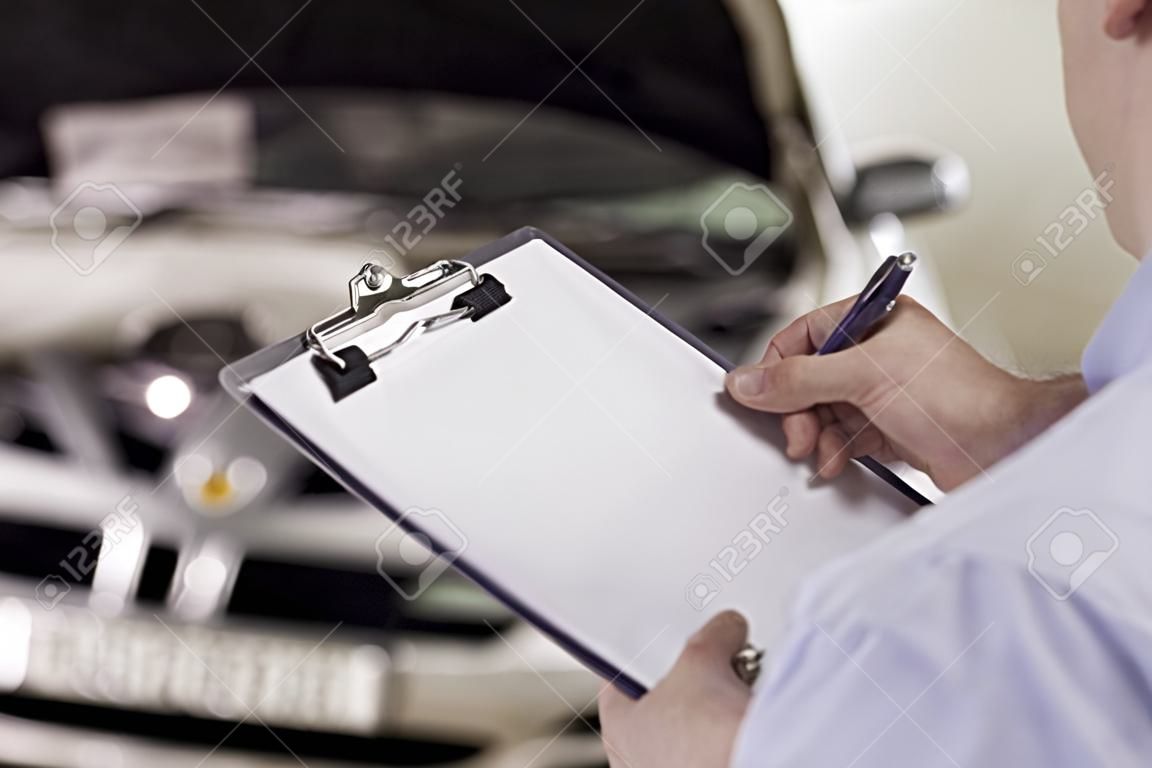 Close up of a man holding a clipboard in a garage