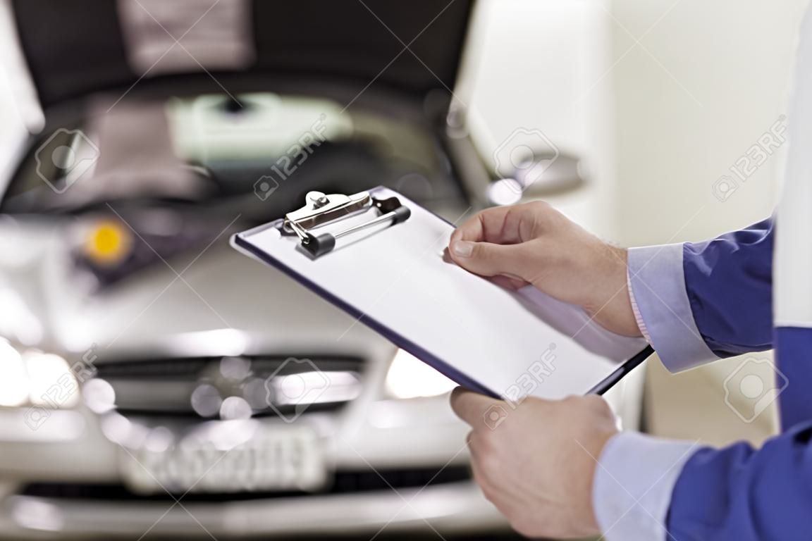 Close up of a man holding a clipboard in a garage