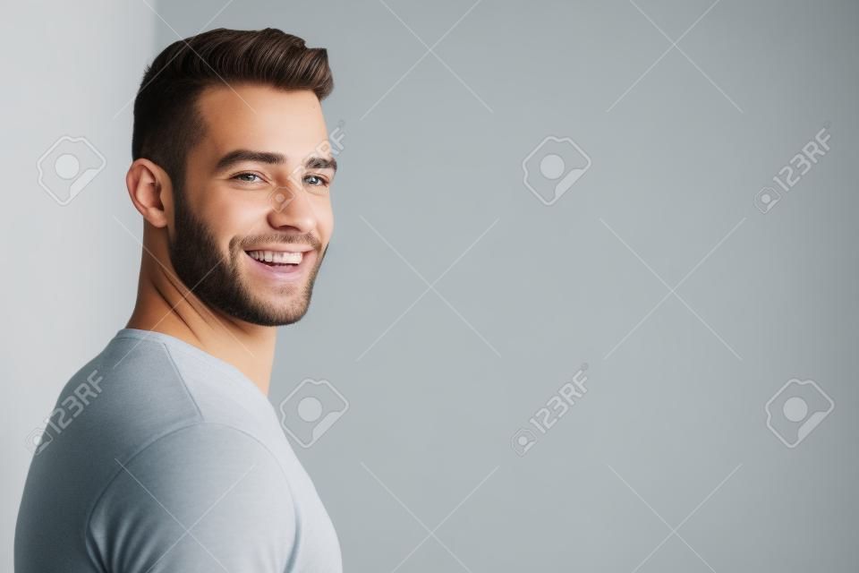 Vista lateral, retrato, de, sorrindo, homem jovem, sobre, fundo branco
