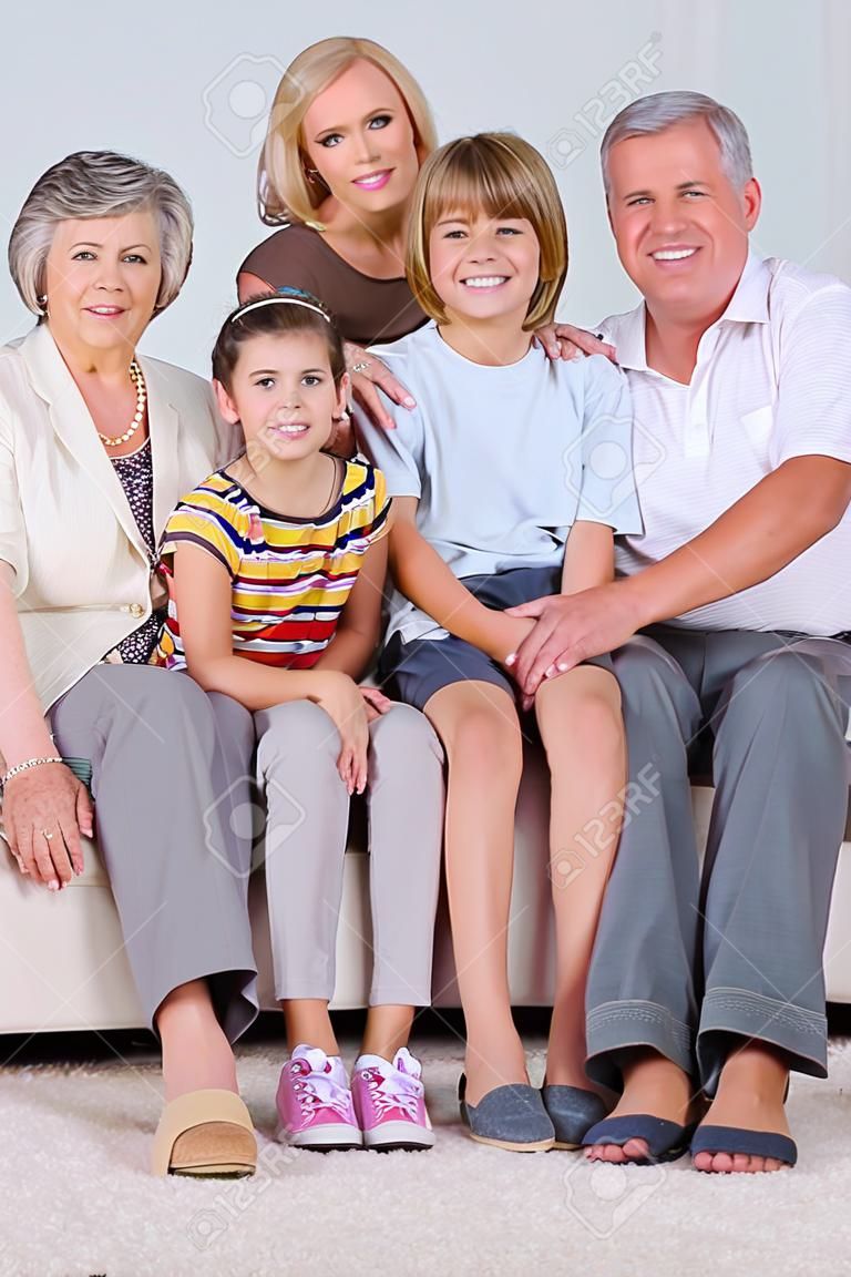 Ritratto di famiglia guardando fotocamera in salotto
