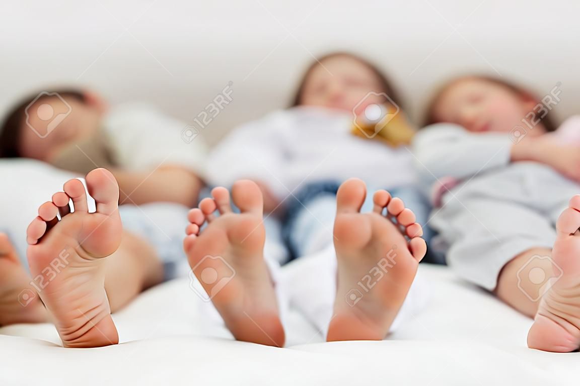 Primer plano de los pies de una familia durmiendo