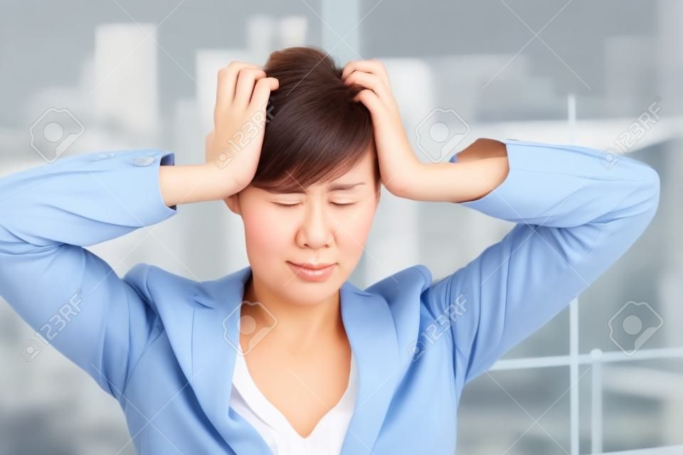 Frustrated businesswoman with hands on head and eyes closed