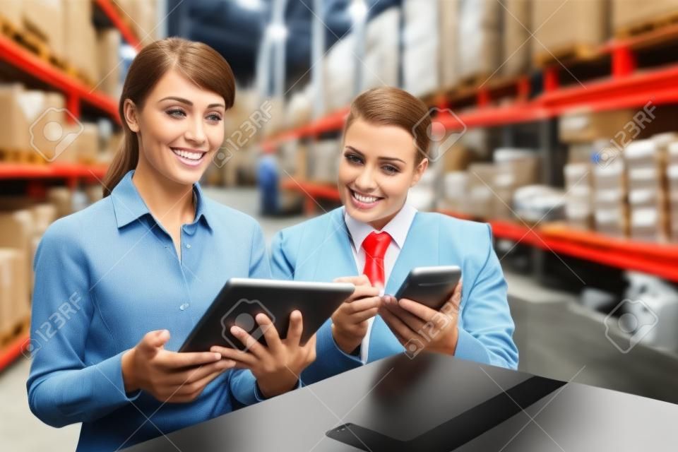 Menedżerów Warehouse patrząc na tablet PC w dużym magazynie