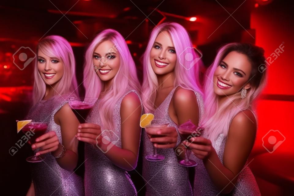 Jolies amis boivent des cocktails ensemble à la discothèque