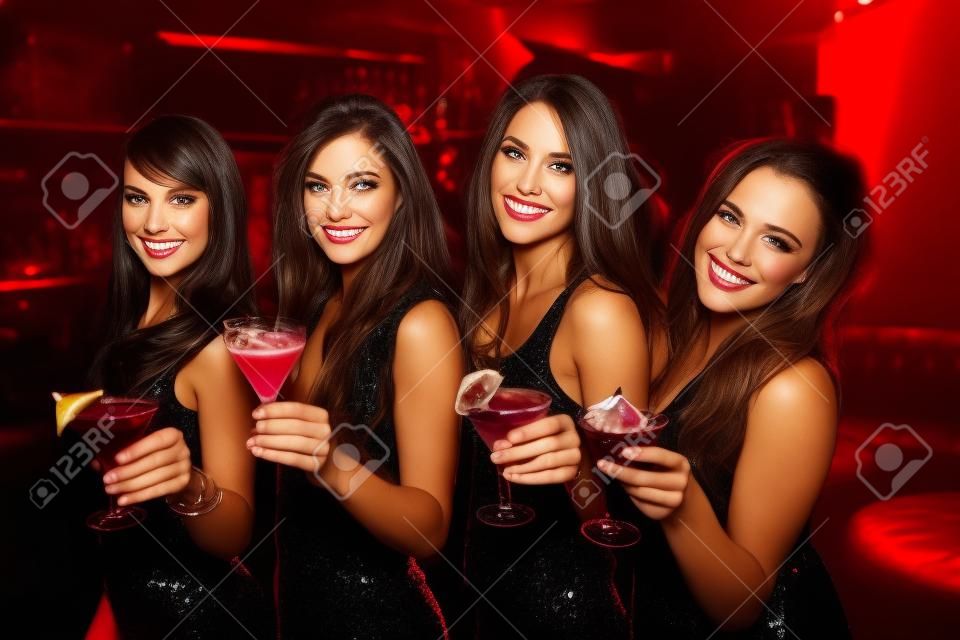 Pretty friends drinking cocktails together at the nightclub