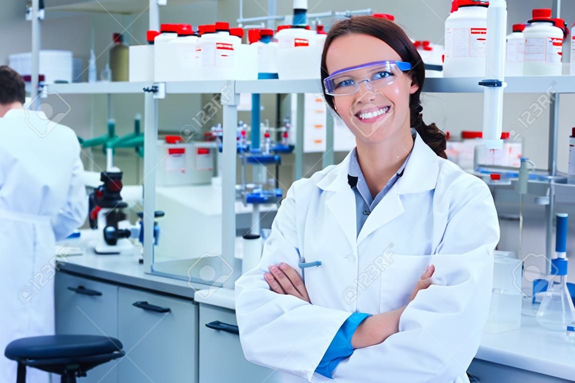 Portrait of a smiling chemist with arms crossed in the laboratory