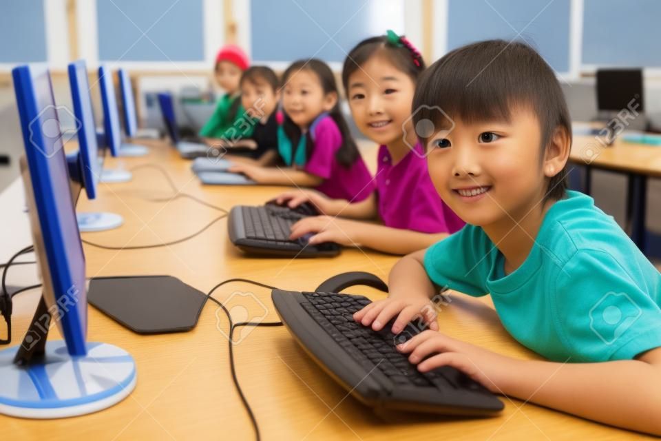 Alumnos lindos en la clase de computación en la escuela primaria