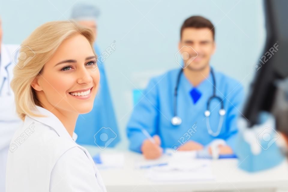 Patiënt en arts glimlachen op camera in medisch kantoor