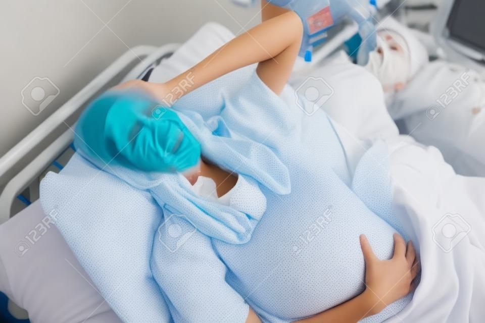 Pregnant woman having birth pangs in hospital room