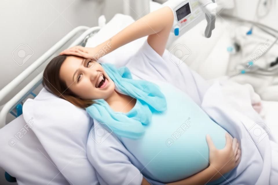 Pregnant woman having birth pangs in hospital room