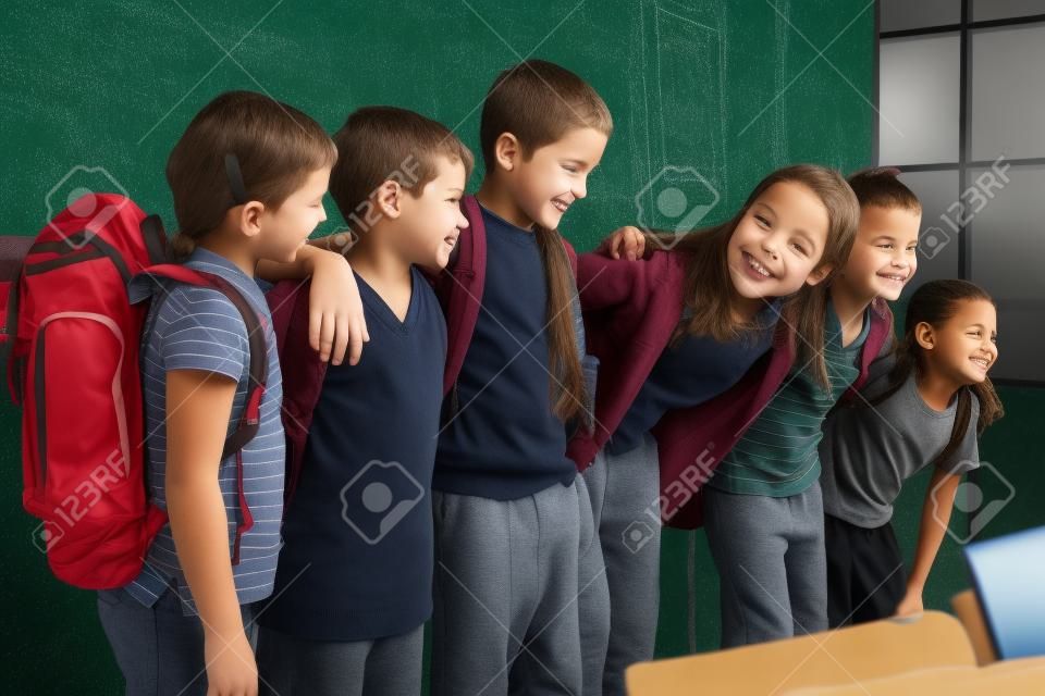 Les élèves debout devant tableau noir à l'école primaire