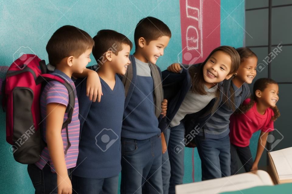 Les élèves debout devant tableau noir à l'école primaire