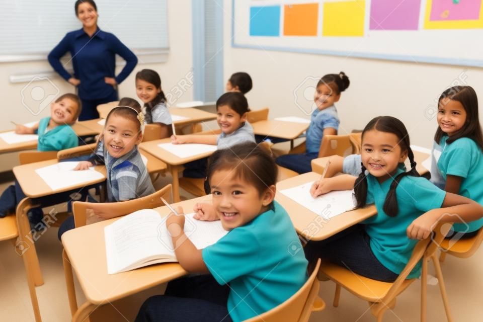 Die Schüler in die Kamera während des Unterrichts an der Grundschule lächelnd