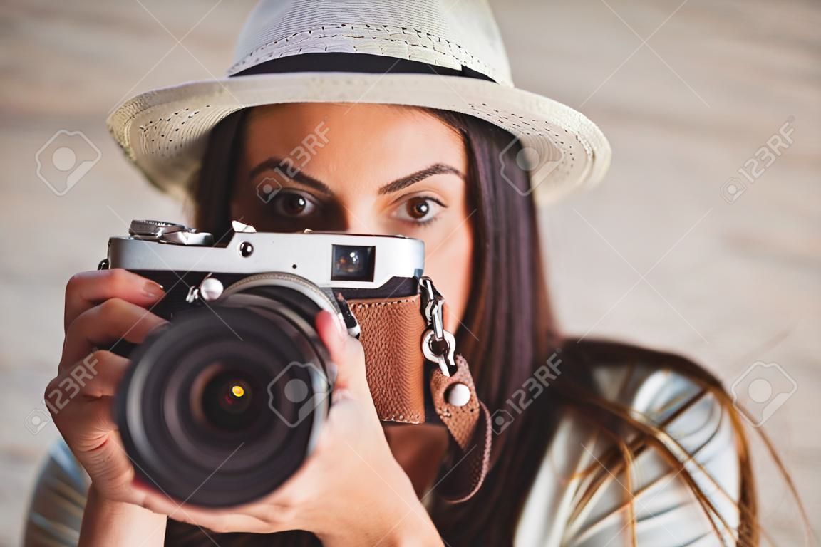 Hübscher Hippie mit ihrem Vintage-Kamera auf hölzernen Planken Hintergrund