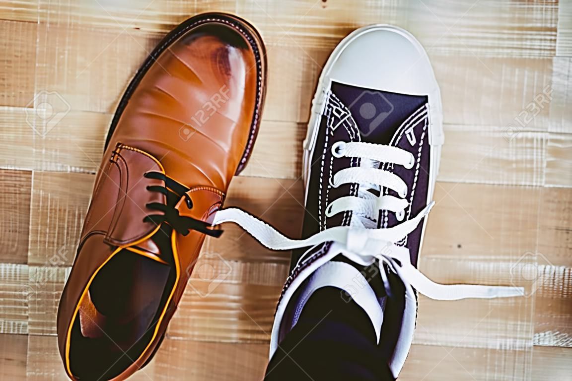 Blick auf zwei verschiedene Schuhe auf Holzbrett