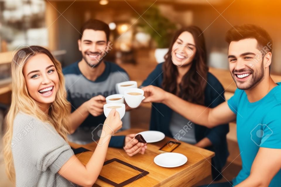 Lächelnde Freunde, die zusammen Kaffee an der Kaffeestube genießen