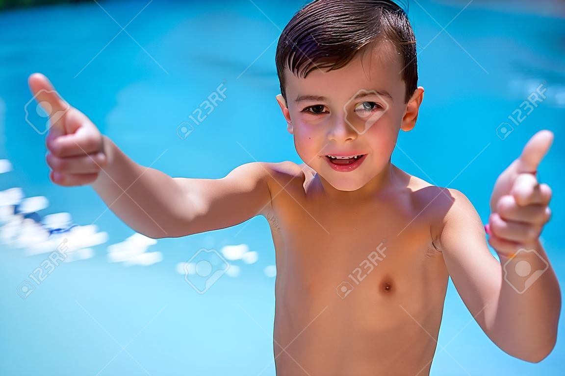 Retrato de muchacho sin camisa haciendo un gesto en la piscina