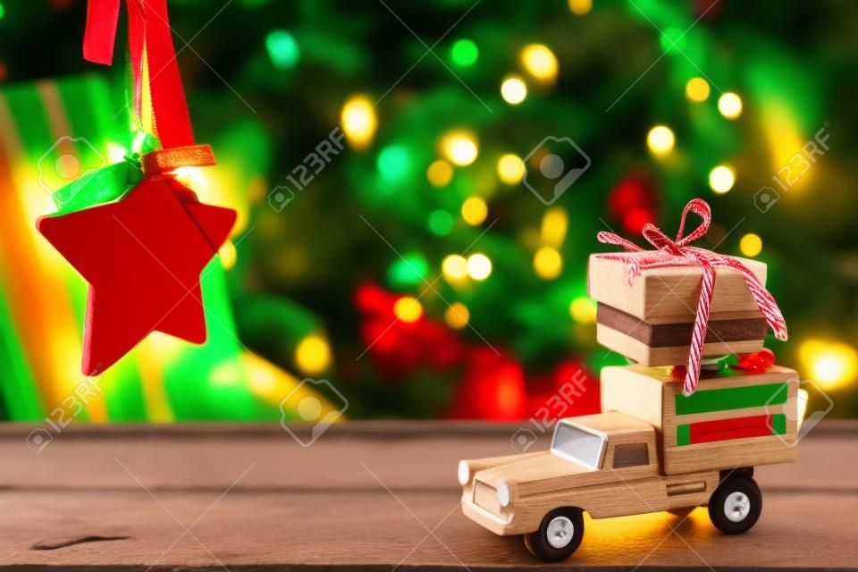 Car toy on wooden surface against christmas decoration hanging on chair