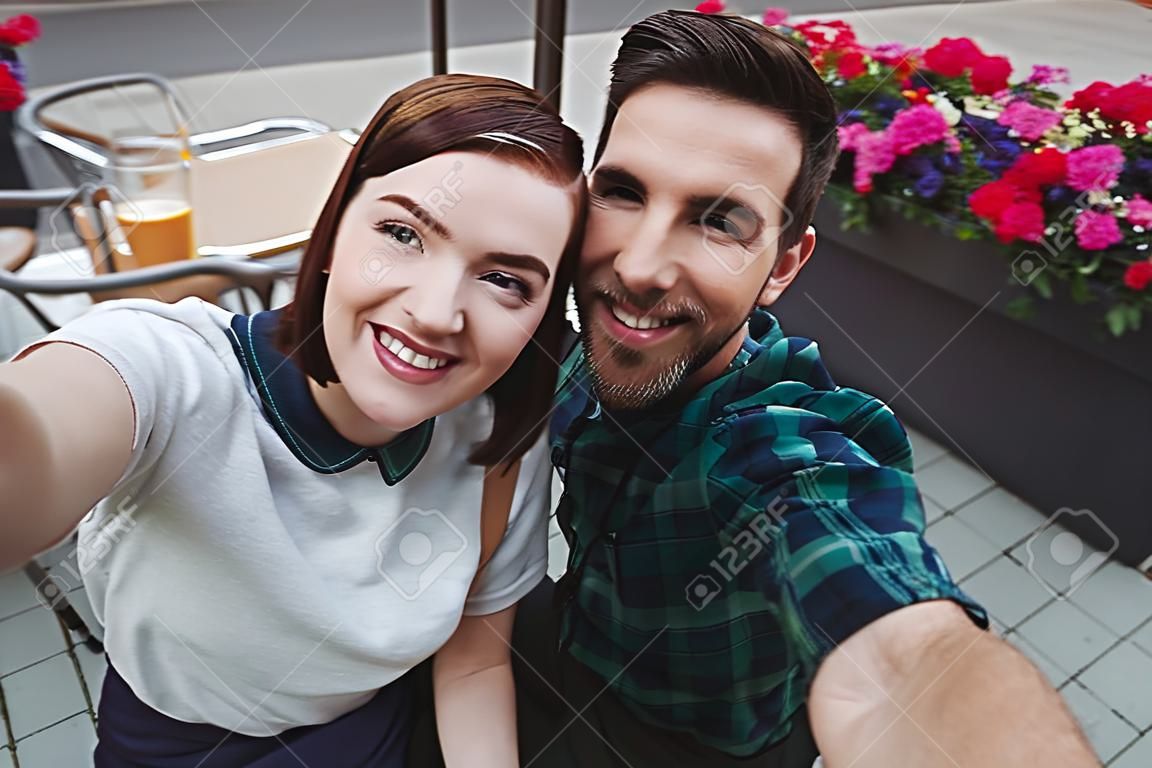 Portrait of couple posing for selfie in cafeteria