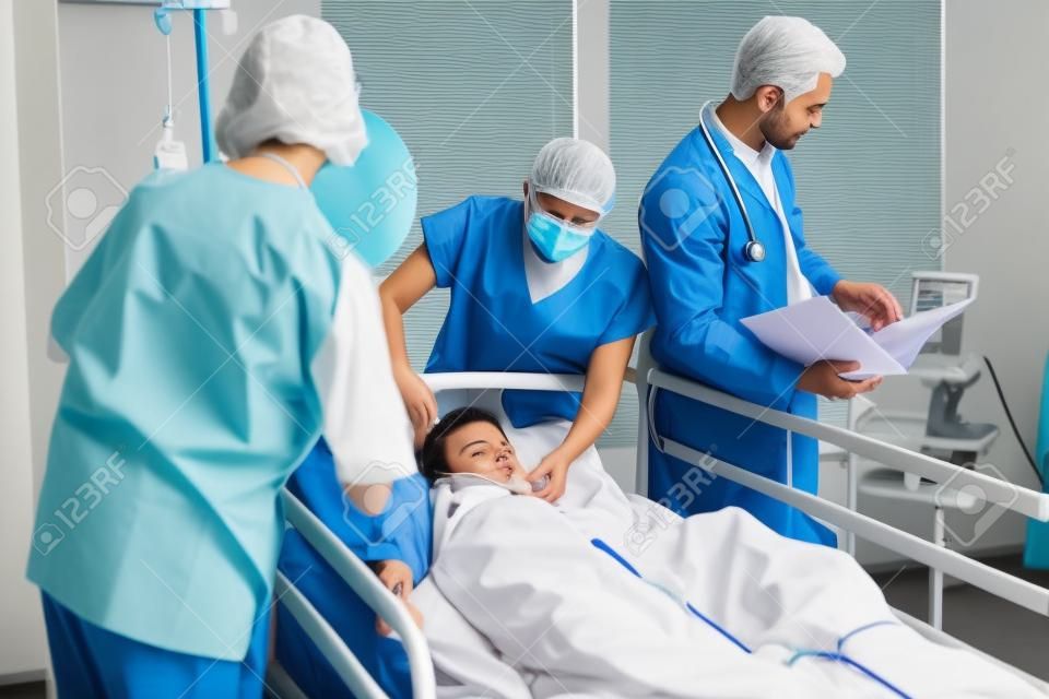 Doctors examining patient in ward at hospital