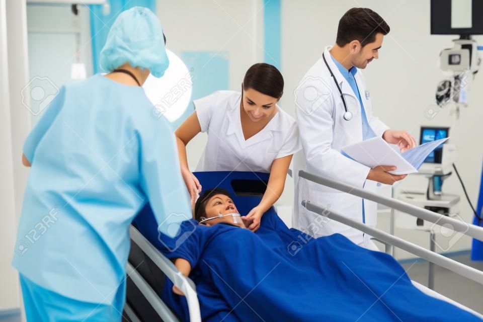 Doctors examining patient in ward at hospital