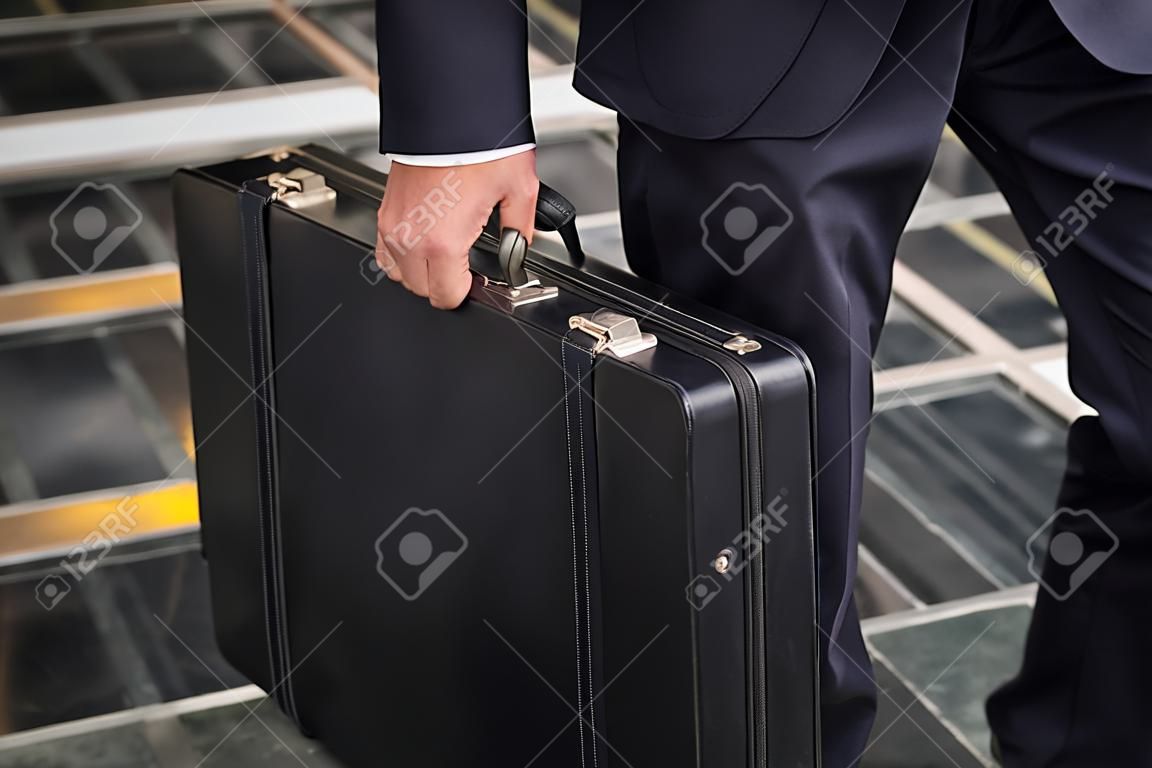 Close-up of a business man carrying briefcase