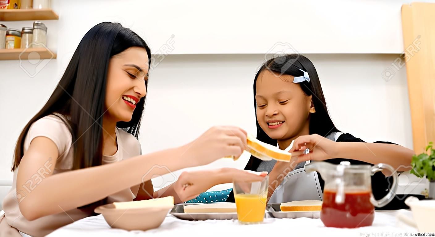 Matka i nastoletnia córka robią razem kanapki w kuchni w domu. rodzinny szczęśliwy czas. kwarantanna podczas wybuchu koronawirusa