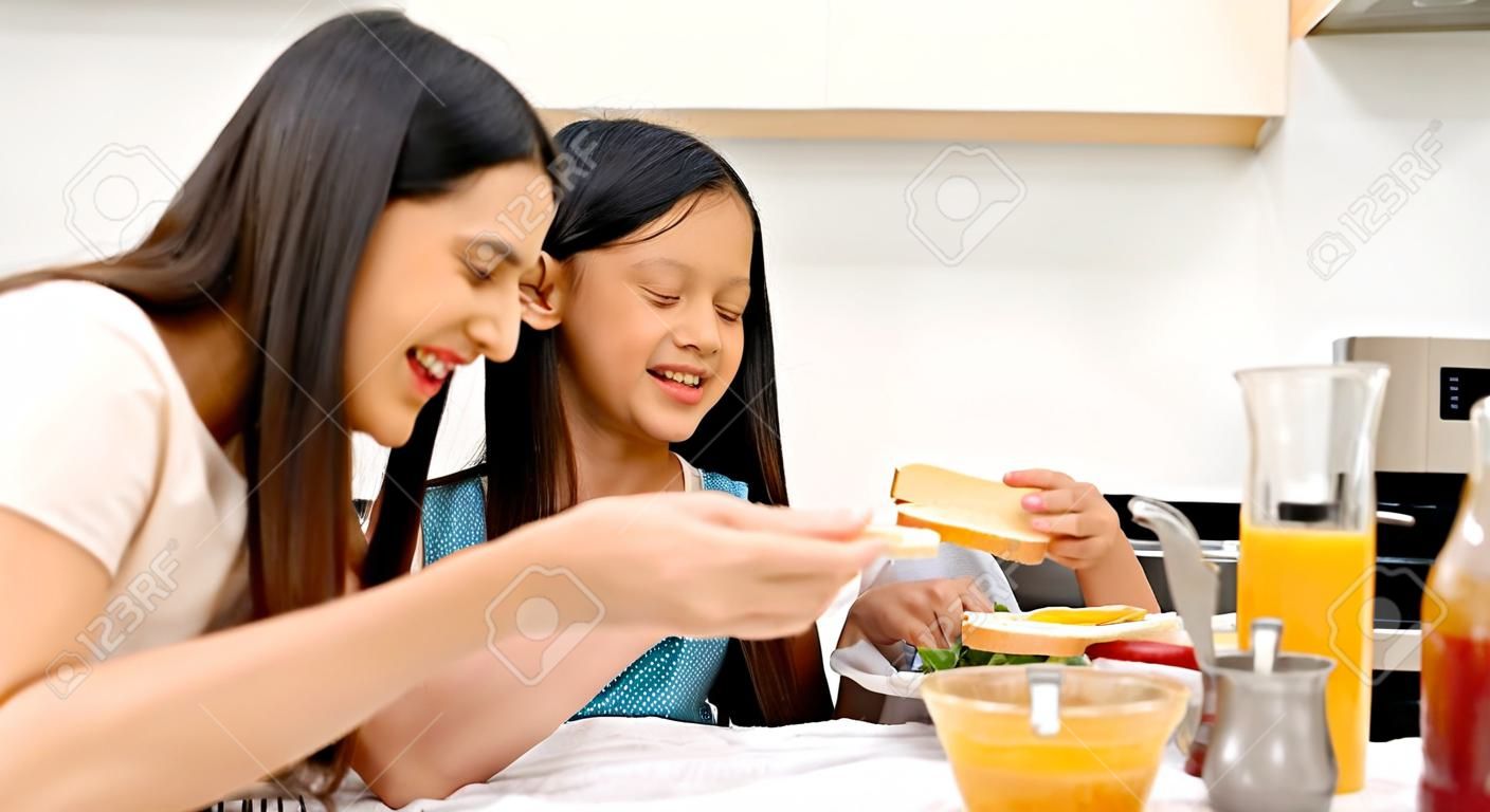 Matka i nastoletnia córka robią razem kanapki w kuchni w domu. rodzinny szczęśliwy czas. kwarantanna podczas wybuchu koronawirusa