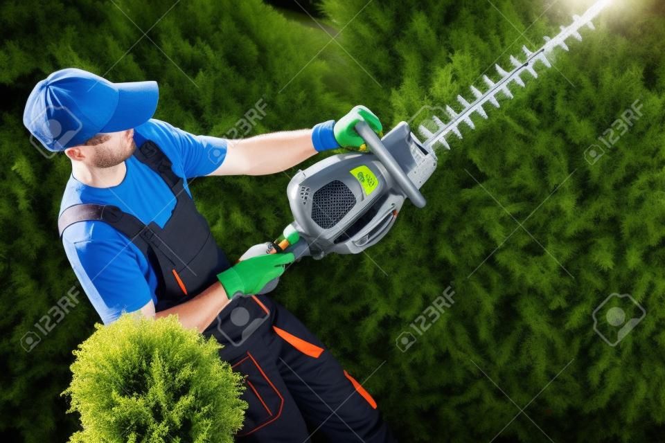 Giardiniere con professionale Trimmer benzina Hedge sul luogo di lavoro.