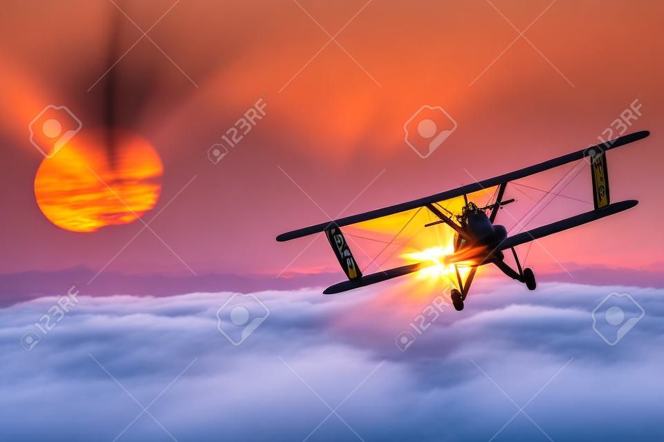 飛機上面的雲在日落。大飛機飛行冒險。雙翼飛機飛行。