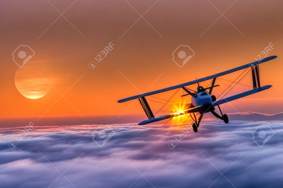 일몰 동안 구름 위의 비행기입니다. 그레이트 비행기 비행 모험. 복엽기 비행.