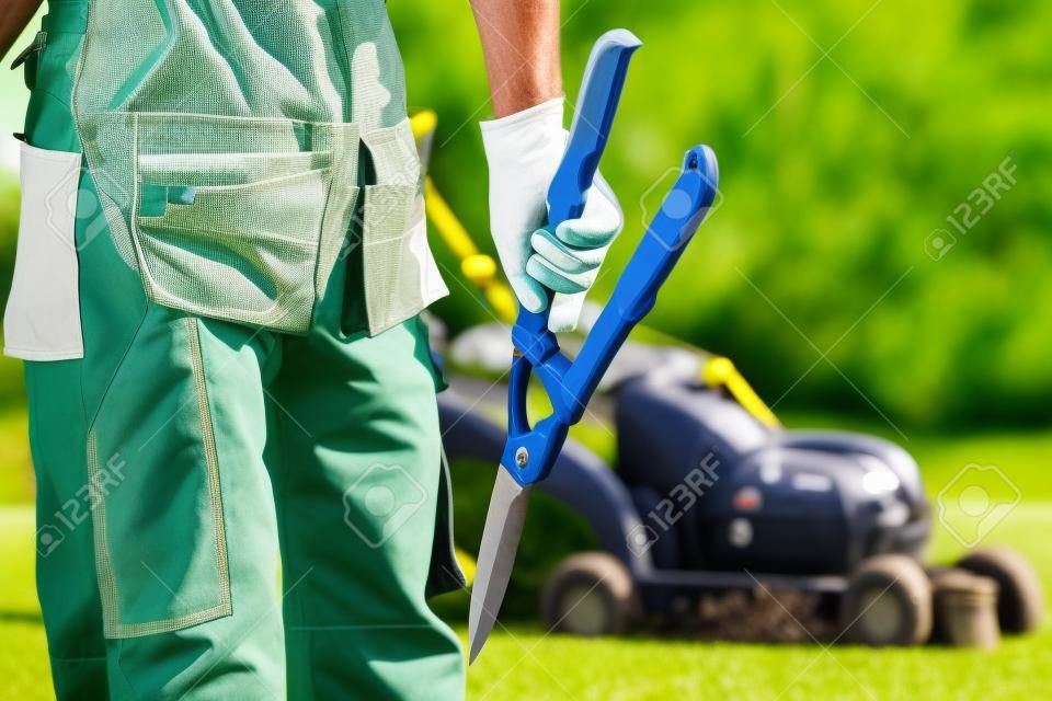 Landscaping Professional. Pro Gardener with Large Scissors and Other Gardening Equipment.