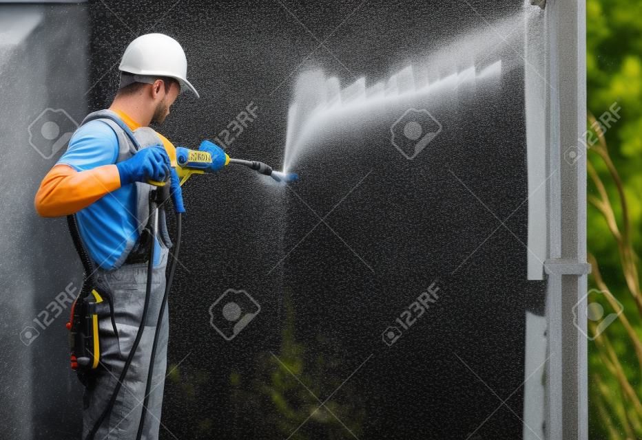 パワーワッシャーを使用して作業者による高度圧力洗浄を構築します。家の外壁をリフレッシュ。