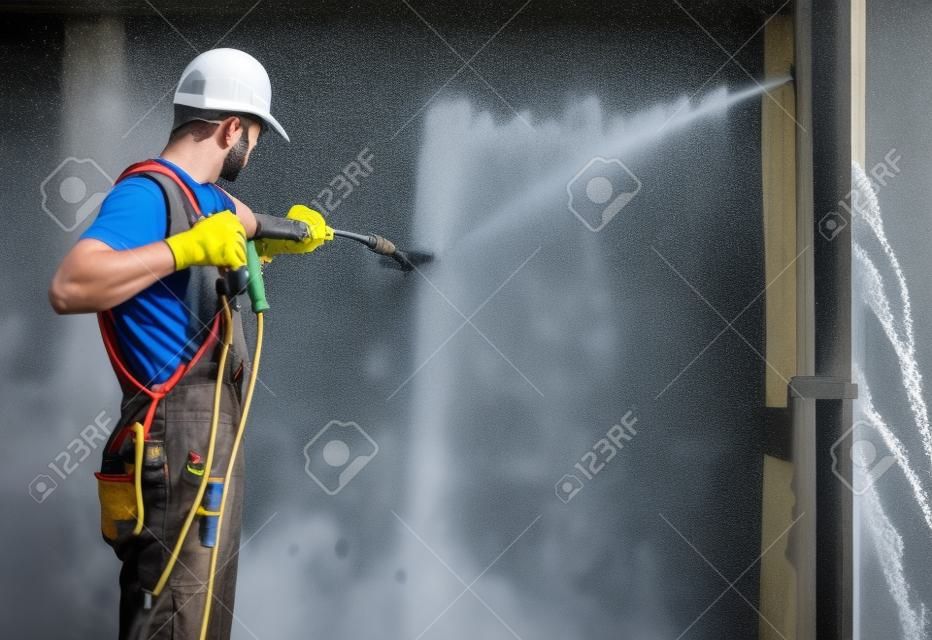 パワーワッシャーを使用して作業者による高度圧力洗浄を構築します。家の外壁をリフレッシュ。