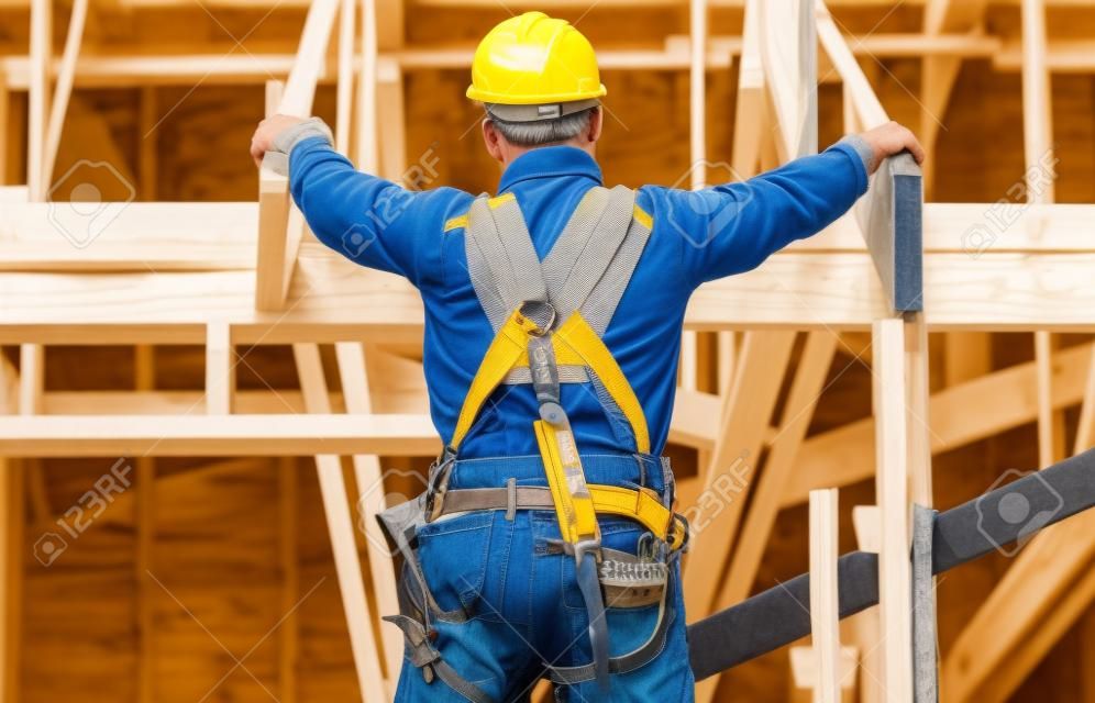 entrepreneur avec ceinture à outils et casque de sécurité devant le chantier  de construction à ossature bois 16360571 Photo de stock chez Vecteezy