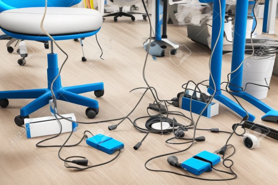 Concept of clutter in office. Unwound and tangled electrical wires under the table. 5S system of lean manufacturing